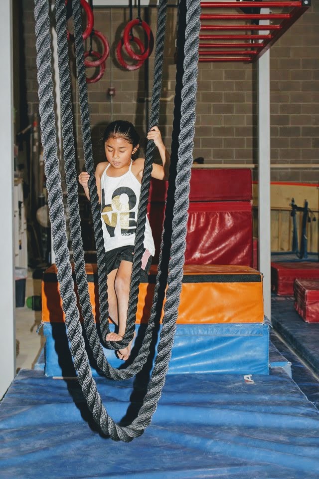 Child climbing on Ninja Warrior course equipment